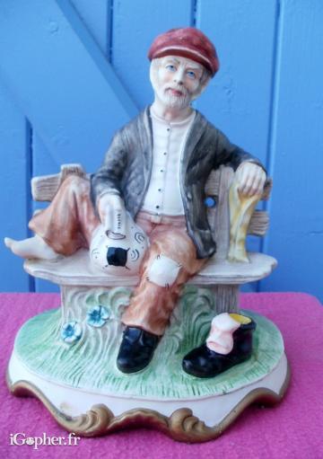 Statuette en biscuit d'un marin sur un banc